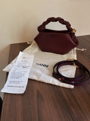 Ganni bau bag - Tjena! Säljer nu denna väldigt snygga Ganni bau bag mini väskan i färgen vinröd, allt på bilden följer med, så alltså dustbag, snöret men också fysiskt kvitto. Väskan är köpt i Danmark och har knappt använts något alls och är fortfarande sprillans ny med inga täcken på användning. Hör av dig i dm vid intresse eller vid frågor om annat!
