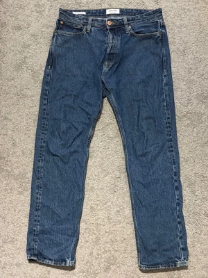 Jack&Jones Blåa Jeans 30/32 - Säljer ett par blåa jeans från Jack&Jones med avslappnad passform, modell Relaxed Chris. Sköna och stilrena jeans. Storlek W30 L32. Hör av dig vid frågor.