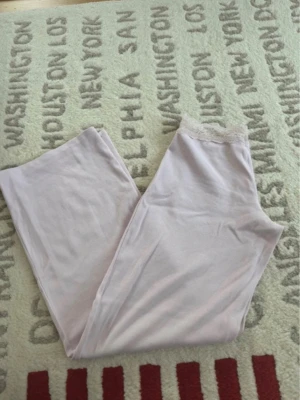 Ljusrosa mjuka loungewear-byxor - Supermysiga ljusrosa loungewear-byxor med breda ben och elastisk midja med spetsdetalj. Perfekta för chill hemma eller när du vill vara extra bekväm. Tunt och mjukt material som känns skönt mot huden.