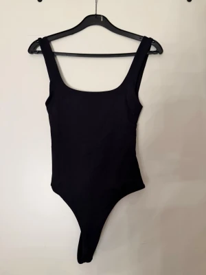 Svart body från Zara - Säljer denna helt oanvända svarta body med prislapp kvar. Den är jätte fin med öppen rygg och i storlek S. Perfekt inför fester och sommaren🥰