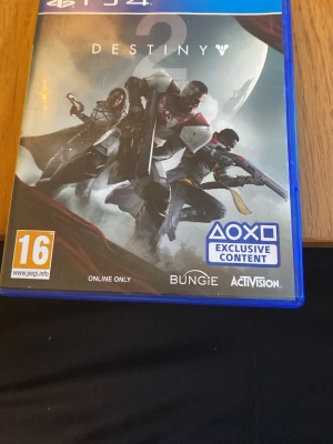 Destiny 2 till PS4 - Destiny 2 till Playstation 4 är ett actionfyllt sci-fi spel från Bungie och Activision. Omslaget är blått med tre beväpnade karaktärer mot en måne i bakgrunden. Spelet har exklusivt PS4-innehåll och kräver internetuppkoppling. Och det är fel skiva