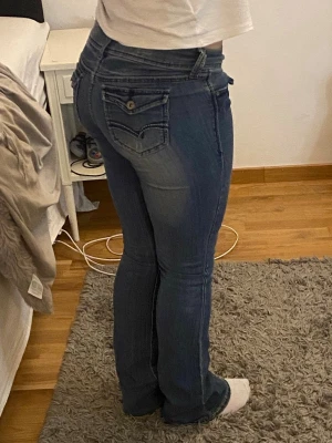 Lowwaist bootcut jeans - Säljer ett par helt nya blå bootcut jeans med slitningar på låren och knäna. Jeansen har låg midja och lätt utsvängda byxor! Så snygg passform med en lite tunnare material så formar jätte fint💕Storlek S men passar även M💕 Postar inom 24h!