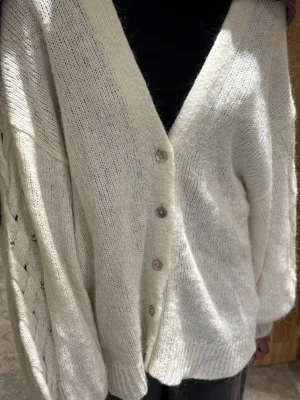 Vit cardigan Gina Tricot  - Säljer vit cardigan med knappar från Gina Tricot. Storlek L men tvättat två o använt två gånger så passar storlek M. 