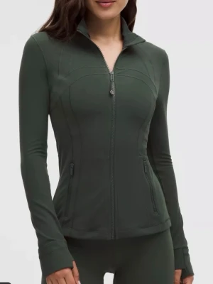 Lululemon define jacket - Sportig mörkgrön zip-jacka från Lululemon med figurnära passform, hög krage och långa ärmar. Jackan har två dragkedjefickor fram och tumhål vid ärmsluten. Perfekt för träning eller som lager på lager. Tillverkad i stretchigt funktionsmaterial. Använd 2 gånger