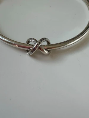 Silverfärgad infinitysymbol berlock - Snygg och trendig berlock från Pandora ordinarie pris är 249kr första bilden ser den rosa ut på grund av mobilskalet💞