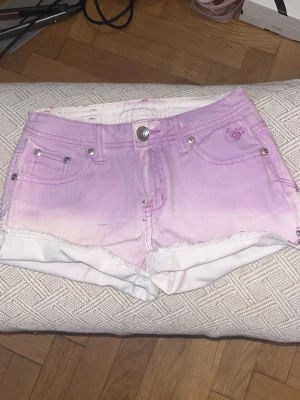 Lila och vita shorts från Juicy Couture - Ett par jätte snygga shorts som är vintage! Shortsen har silverfärgade nitar och broderade fickor. Perfekta för sommaren!