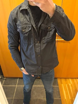Morris Overshirt - Säljer min pojkväns stilrena mörkblåa overshirt från Morris då den tyvärr inte kommer till användning. Den är knappast använd och har inga defekter, funkar perfekt som vårjacka. Han är 183cm lång. Hör av er vid frågor❣️
