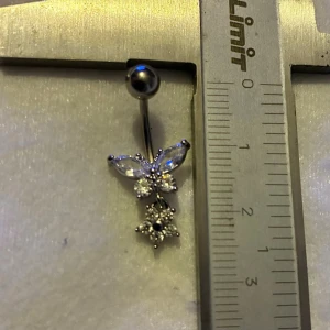 ✨ NY oanvänd navelpiercing med hänge - Kirurgiskt stål 316L  - ✨ NYTT oanvänt smycke i kirurgiskt stål! 🌸 Hållbart & Rostfritt: Slitstarkt 316L-stål som inte oxiderar eller rostar av fukt. 🌸 Säkert: Industristandard, skonsamt för läkta piercingar.  🛍️ 30 % BUNDLE-RABATT! Köp fler artiklar från min shop och få 30 % på allt! ✨ 📦 Frakt: Endast spårbart via Plick SafePay för vår trygghet.