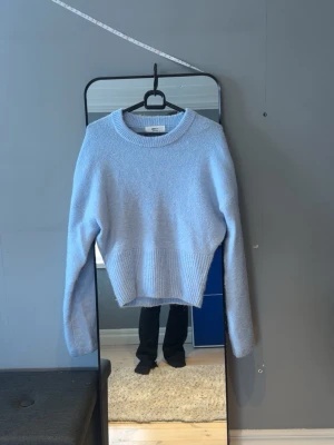 Ljusblå stickad tröja från Gina Tricot - Mysig ljusblå stickad tröja från Gina Tricot med rund halsringning och bred ribbstickad kant nertill. Säljer då det knappt kommer till använing! Stolek s! Pris kan diskuteras!