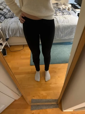 Svarta leggings med hög midja - Säljer ett par svarta leggings med hög midja och tight passform. De är stretchiga och sitter snyggt längs benen. Perfekta till en stickad tröja eller oversized hoodie. Materialet känns mjukt och följsamt mot huden. Low waist med jeansmönster.