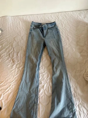 Ljusblå bootcut jeans från Denim Co. - Säljer ett par ljusblå bootcut jeans från Denim Co. Jeansen har klassisk femficksdesign, hög midja och vida ben. Tillverkade i mjukt denimtyg som är bekvämt att bära. Perfekta för dig som gillar retrostil och vill ha ett par snygga jeans till vardags.