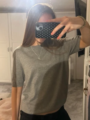 Grå stickad topp med kort ärm - Enkel och stilren grå topp med korta ärmar och rund hals, inga synliga skador!💓💓💓