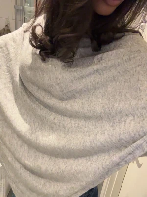 Ljusgrå poncho - En enkel och stilren ljusgrå poncho. Den har en avslappnad passform och är tillverkad i ett mjukt material som känns skönt mot huden. Perfekt att matcha med jeans för en casual look☺️