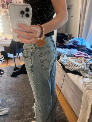 Baggy jeans - Säljer ett par ljusblå lågmidjade baggy jeans Levi's med slitningar och stora hål på knäna. Klassisk femficksmodell med hög midja och vintagekänsla. Perfekta för en avslappnad och trendig look.
