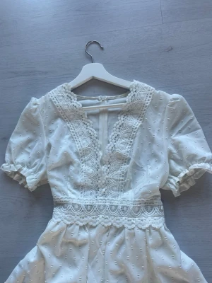 Vit spetsklänning med puffärm - Vit spetsklänning, använd till en skolavslutning men aldrig mer, vet storlek och märke men brukar ha S.