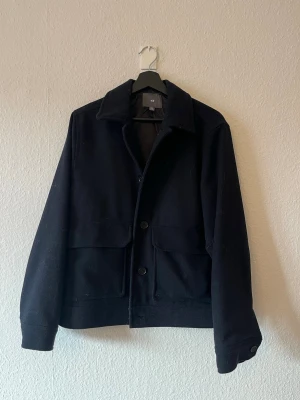 Mörkblå kappa från H&M - Mörkblå kappa i storlek M som inte kommit till användning. från H&M
