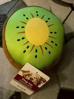 Grön hundleksak kiwi Pet Club - Rolig vatten hundleksak från Pet Club formad som en kiwi. Leksaken är rund, har grön ovansida med gul mitt och svarta detaljer som liknar kiwifrön. Tillverkad i mjukt tygmaterial och passar perfekt för lekstunder med din hund.
