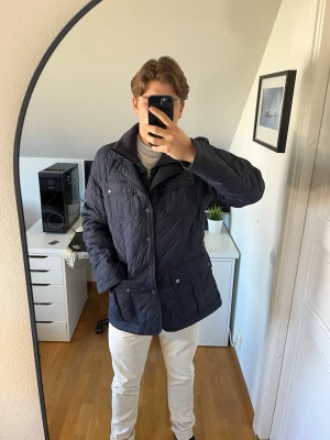 Mörkblå quiltad jacka med fickor - Snygg mörkblå quiltad jacka med flera praktiska fickor framtill och tryckknappar. För stor för mig som är 178 cm. Hör gärna av dig vid frågor!