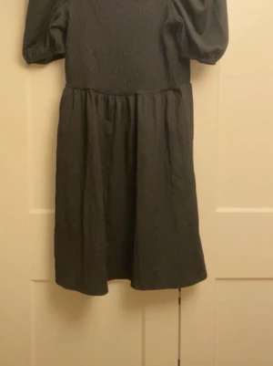 Svart klänning - Stilren svart kortklänning med puffärmar och rynkad överdel.