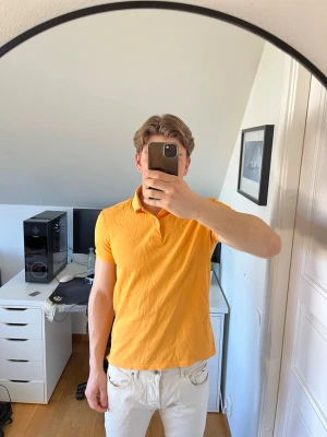 Gul pikétröja från J.Lindberg - Snygg gul pikétröja ifrån J.Lindberg med klassisk krage. Den är tillverkad i 100% bomull. Hör gärna av dig vid frågor! 