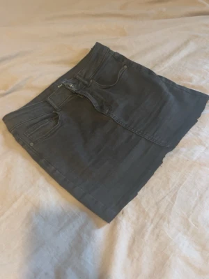 Svart jeanskjol från Pieces - Säljer en svart jeanskjol från Pieces med klassisk femficksdesign och knapp- samt dragkedjestängning framtill. Kjolen har en rak passform och är i kort modell, perfekt till många olika stilar.