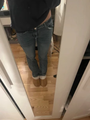 Blå raka jeans med låg midja - Säljer ett par klassiska blå jeans med rak passform och låg midja. Jeansen är tillverkade i ett slitstarkt denimtyg. Perfekta för en avslappnad och trendig look. Aldrig använda