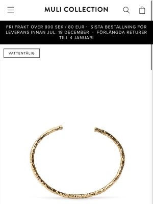 Guldfärgat hamrat armband Muli - Snyggt guldfärgat armband från Muli Collection med hamrad yta som ger en unik och trendig look. Armbandet är öppet och har en minimalistisk design som passar perfekt till flera olika stilar. Tillverkat i metall och är vattentåligt.