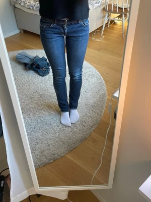 Skinny lowrise jeans  - Säljer ett par klassiska blå skinny jeans med låg midja och smal passform hela vägen ner. Jeansen har fem fickor och stängs med dragkedja och knapp. Perfekta till vardags och lätta att matcha med olika stilar.