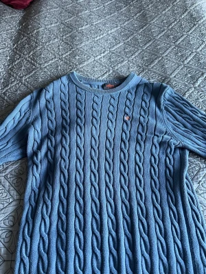 Blå kabelstickad tröja Morris - Snygg blå kabelstickad tröja från Morris med ribbade muddar.  I storlek M bara att höra av sig vid frågor.