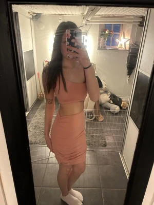 Ljusrosa oneshoulder klänning - Trendig ljusrosa oneshoulder klänning med cut-out detalj i midjan. Klänningen är tight och kort, perfekt för dig som vill sticka ut. Tillverkad i ett stretchigt material som formar sig snyggt efter kroppen. Kjolen och toppen sitter ihop på ena sidan.💕