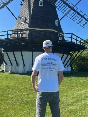 Voronado Saint Tropez t-shirt - Vit t-shirt från Voronado Yacht Club med stort tryck på ryggen som visar en yacht och texten 'Saint Tropez'. Klassisk passform och korta ärmar, perfekt för en chill och stilren look.