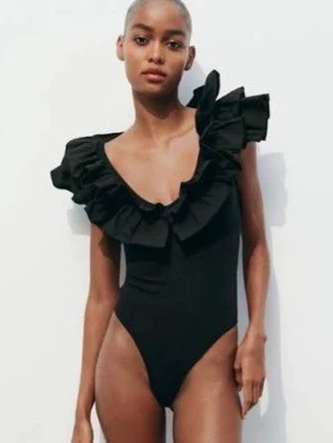 Svart body  med volangdetaljer - Trendig svart body med djup urringning och stora volanger längs axlar och halsringning. Snygg och stilren modell som ger en unik look.  Den är slutsåld och väldigt populär. Hör gärna av er om ni har frågor🌟🌸