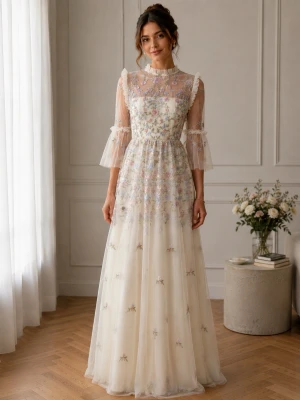 Klänning By Malina - Drömmig långklänning i ljus cremefärg med blommigt broderi och transparent överdel. Klänningen har volangdetaljer, hög hals och trekvartsärmar i tunn tyll. Perfekt för dig som vill ha en romantisk och elegant look.