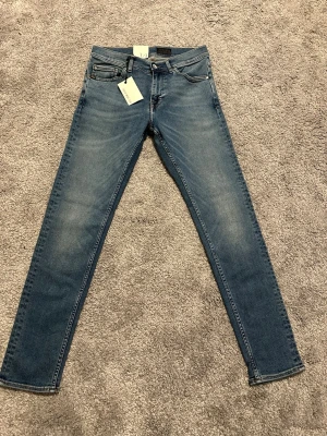 Tiger of sweden jeans 👖  - Snygga blå slim fit jeans från Tiger of sweden med klassisk femficksdesign och lätt slitna detaljer på låren. Jeansen har normal midja, dragkedjegylf och är tillverkade i stretchigt denim för en bekväm passform. Den är helt nya och tveka inte på att höra av dig vid minsta lilla fråga!