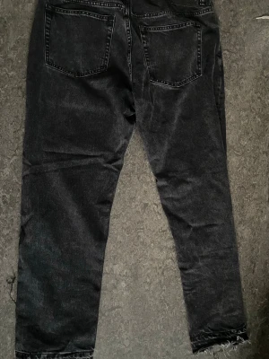 Flared jeans  - Svarta jeans från 157 med raka ben och råa, fransiga benslut. Klassisk femficksmodell i denim med snygg tvättad look. Perfekta för en avslappnad och trendig stil.