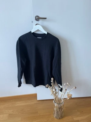 Svart sweatshirt från Topman - En stilren svart sweatshirt från Topman med rund hals och långa ärmar. Tröjan är gjord i mjukt material och har en enkel design utan tryck eller mönster. Perfekt för dig som gillar en clean och klassisk look.