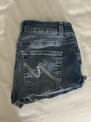 Blå jeansshorts med broderade fickor - Snygga, trendiga blå jeansshorts från nelly! De är helt oanvända och orginalpris är 499. Säljer då jag inte tycker om hur de sitter på mig. Skriv innan köp!