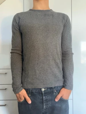 Grå  stickad tröja - Grå stickad tröja från Massimo Dutti. Den är gjord i 100% bomull. Strl S. Inga defekter. Modellen är 178 cm och väger 77 kg. Hör gärna av dig vid frågor!