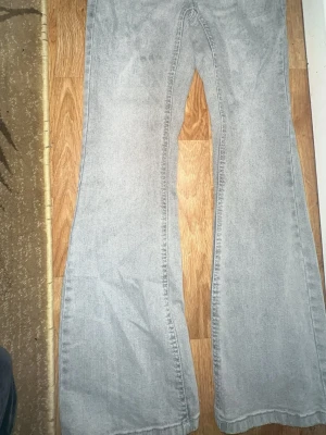 Ljusgrå bootcut jeans från Denim - Säljer ett par ljusgrå bootcut jeans från Denim. Jeansen har klassisk femficksmodell, dragkedjegylf och bälteshällor. Materialet är denim i bomull och passformen är utsvängd nedtill för en retro vibe. Har använt et par få tala gånger. 