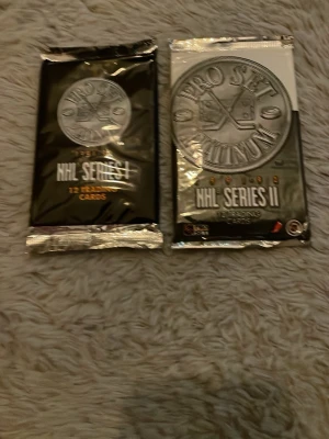 Pro Set Platinum NHL samlarkort - Två oöppnade paket Pro Set Platinum NHL samlarkort, Series I och Series II. Svart och silverfärgad förpackning med logga och text i silver. Perfekt för dig som gillar hockey och samlarkort.
