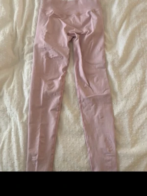 Ljusrosa scrunch thights från FORCY - Säljer ett par ljusrosa scrunch thights från FORCY.  Perfekta för träning eller chill. Diskret logga vid midjan och stilren design.