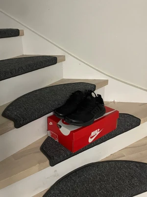 Nike Prestos  - Snygga helsvarta Nike Air Presto sneakers med mesh-ovandel och plastdetaljer vid snörningen. Skorna har en sportig och clean look med diskret Nike-logga på sidan. Perfekta för dig som gillar stilrena och bekväma sneakers.