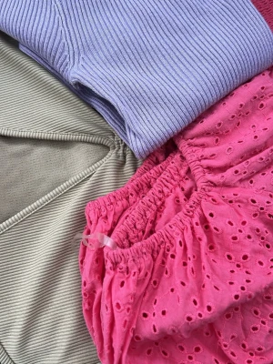3-pack trosor i pastell och rosa - Säljer ett 3-pack trosor i olika stilar: ett par ribbade lila, ett par ljusgrå med enkel design och ett par rosa med broderade hål och liten rosett. Perfekta för dig som gillar variation och färg.  Detta är en  slags av mystery bag där man kan få tre fina tröjor i M storlek för 80kr.