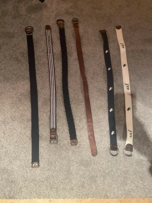 6-pack bälten i olika färger och stilar 50kr styck - Säljer ett paket med sex bälten i olika färger och material. Inkluderar svarta, bruna och beige bälten, ett randigt och två med tryck. Några har metallspännen och detaljer i skinn. Perfekt för att variera din stil och matcha olika outfits.