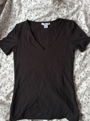 Svart v-ringad t-shirt från butiken New yorker - En enkel svart t-shirt från new yorker med v-ringning och korta ärmar. Tillverkad i mjuk bomull som känns skön mot huden. Perfekt basplagg att matcha med allt och har en klassisk passform.