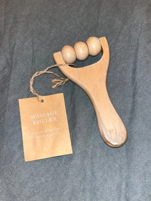 Massage roller  - Massage roller i ljust trä från Design Cave. Den har tre runda kulor som rullar smidigt och ett ergonomiskt handtag för enkel användning. Perfekt för att massera muskler och slappna av. Enkel att ta med tack vare sin kompakta storlek. En liten defekt- se sista bild.