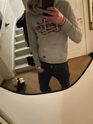 Superdry Hoodie - Riktigt snygg Grå Superdry Hoodie utan nåra defekter. Säljer för den e lite för liten för mig, jag är 180. Levererar inom 1-2 dagar max. Passar folk som har XS och S. 