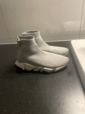 Grå Balenciaga Trainer sneakers - Hej, jag säljer mina gråa Balenciaga skor pga av att det inte passar längre och inte matchar till min stil. Lägg gärna ett bud och låt oss diskutera vidare. 