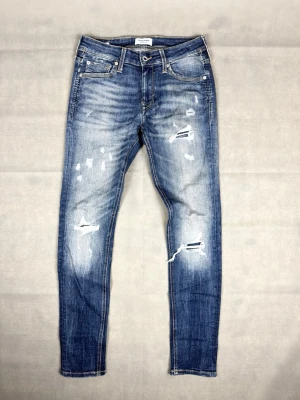 Jack & Jones jeans med slitningar - Jack & Jones jeans med slitningar | Size W30 L32 | Modell: Skinny liam | Skick: 8,5/10 | Mått: Midja: 37 cm Längd: 101 cm | Hör gärna av dig vid frågor och funderingar!🤗