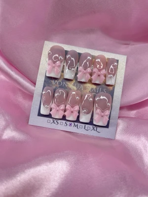 PinkBows (M);Medium Square - Snygga handgjorda press-on naglar i en medium squareform. Naglarna har en mjuk rosanude bas med vit fransk tipp och dekoreras av 3D rosa rosetter. Perfekt för dig som vill ha en söt och trendig look. M: 16 mm, 12 mm, 12,5 mm, 11,5 mm, 10 mm
